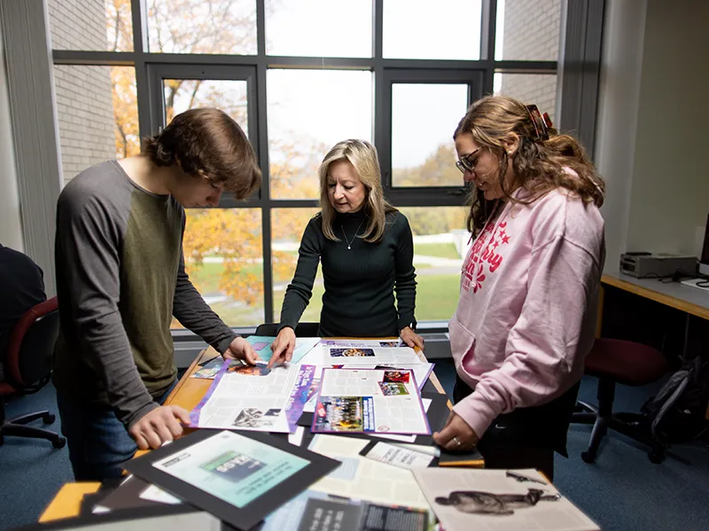students and a professor browsing marketing materials