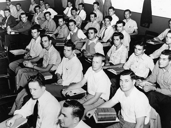 archival photo of the first students at King's College sitting in a classroom