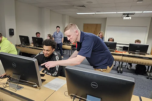 students pointing at a computer monitor