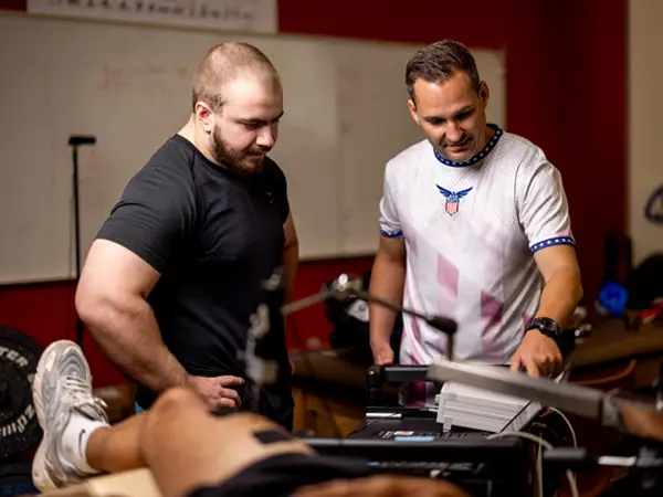 student and professor pointing at exercise equipment