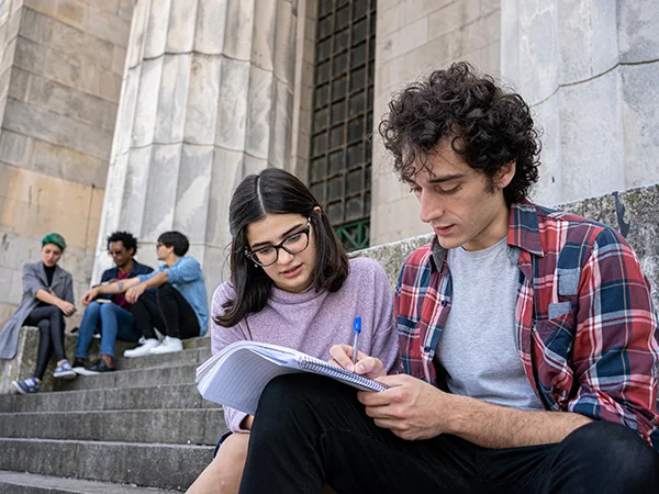students studying on the steps of a historic building