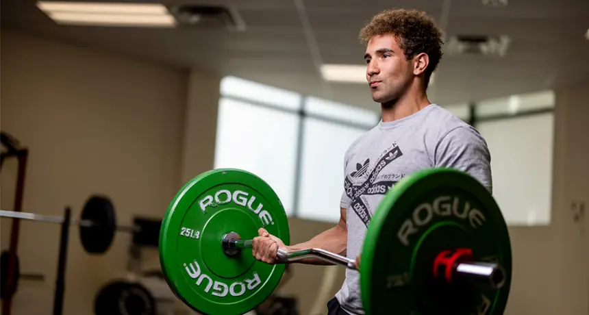 student lifting a barbell