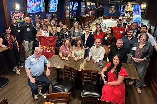 alum pose at a bar