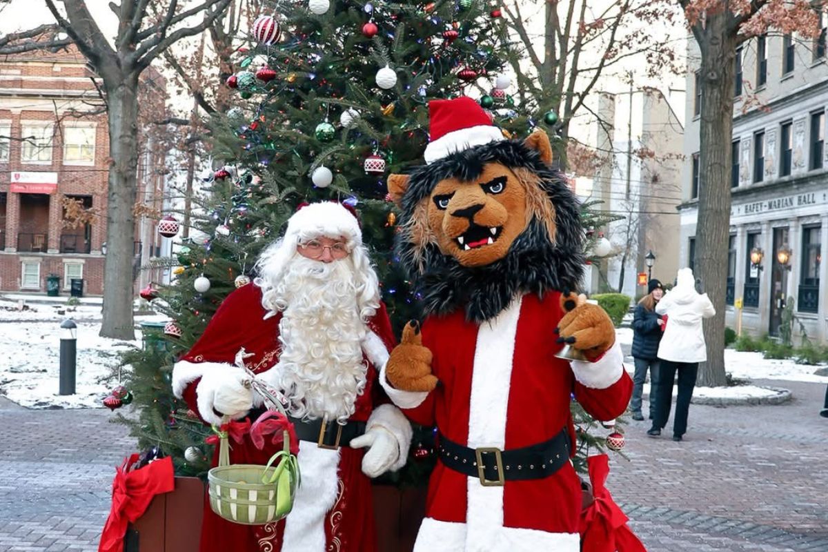 Santa and King's Mascot, Leo the Lion, pose in front of the Christmas tree. 