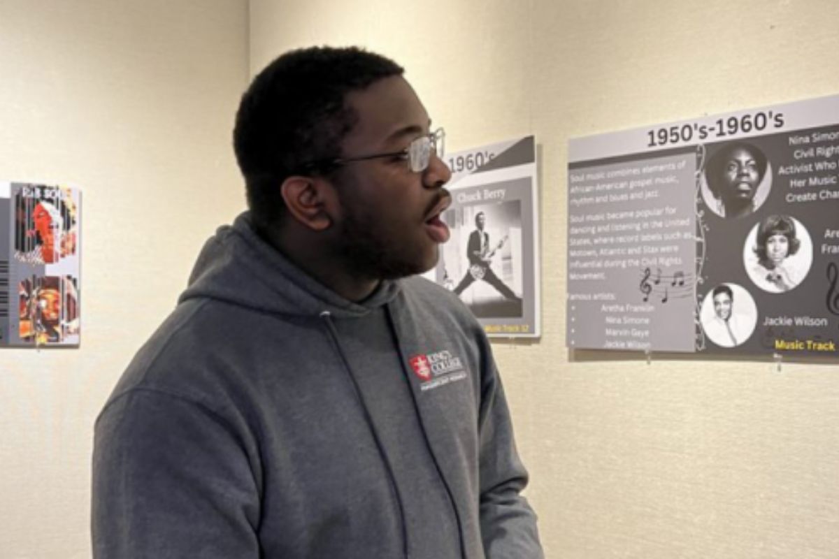 Joseph stands next to art exhibit