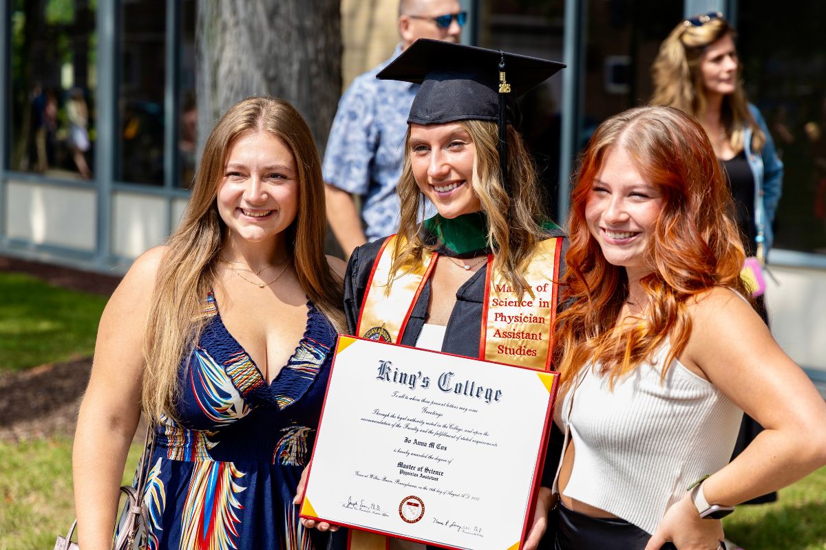 Graduates posting with family and friends with their degree