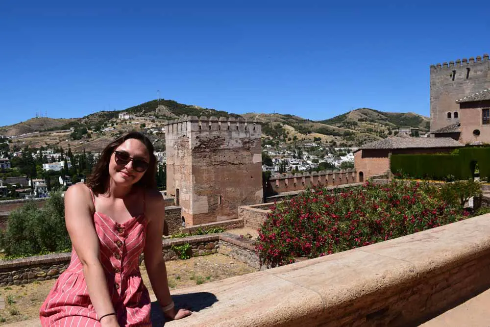woman sits on wall in Spain